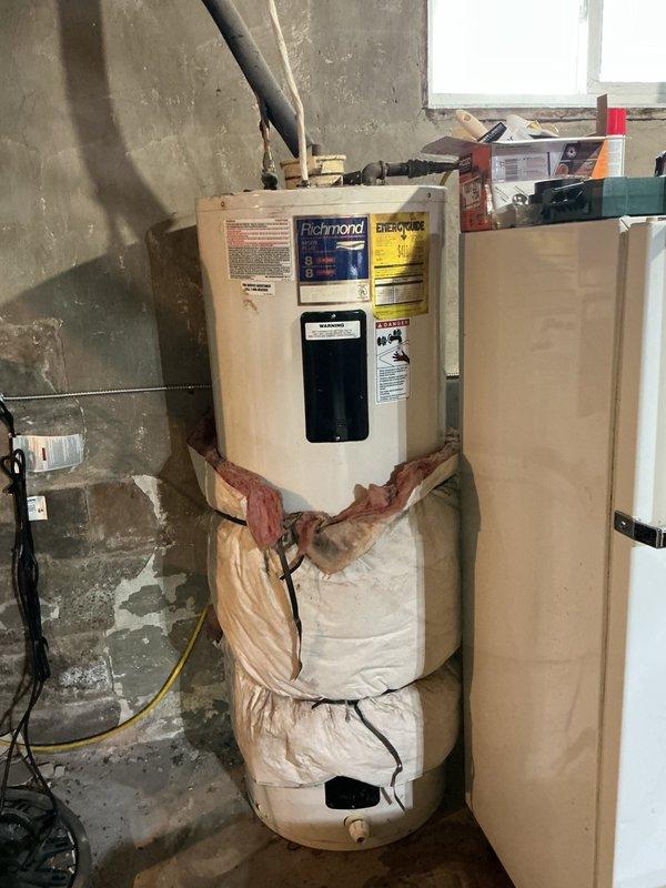 Replaced existing electric water heater with new 50-gallon Richmond brand unit in residential basement location. Drained and removed old water heater, then installed replacement unit using basic installation materials including pipe connections, insulation wrapping, and securing straps. Connected unit to existing electrical service and plumbing lines, verified proper amperage draw to confirm heating element operation, and tested system functionality to ensure proper performance. Installation completed with all applicable safety labels and energy guide information visible, and permit obtained per local code requirements.