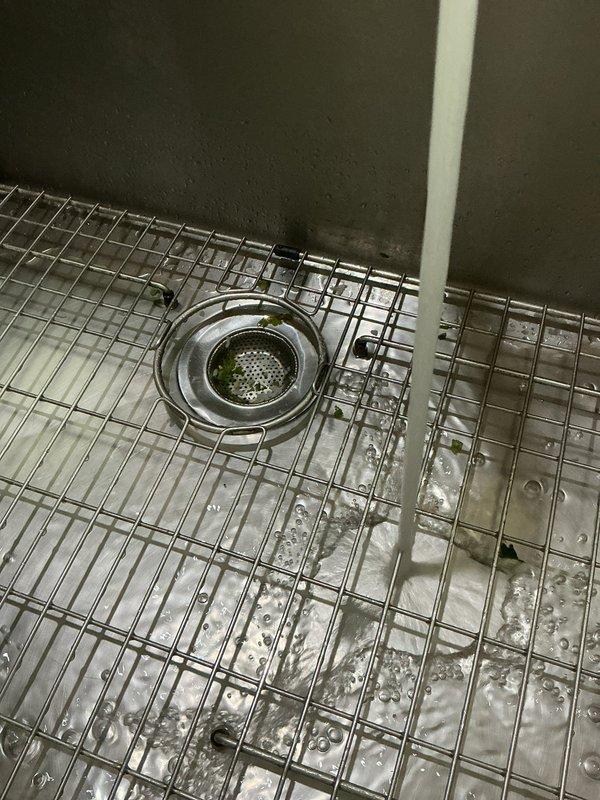 Responded to a kitchen sink backup with water overflow on the floor. Upon inspection, diagnosed a grease blockage in the drain line beyond the trap. Cabled the drain multiple times using professional drain cleaning equipment until the obstruction was completely cleared and proper flow was restored. Verified repair by filling the sink basin to capacity and releasing the water, confirming the drain was functioning properly with no backup or slow drainage. Left the sink operational and draining efficiently.