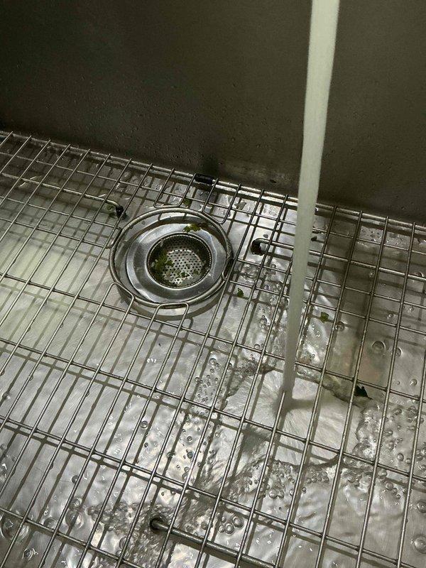 Responded to a kitchen sink backup with water overflow on the floor. Upon inspection, diagnosed a grease blockage in the drain line beyond the trap. Cabled the drain multiple times using professional drain cleaning equipment until the obstruction was completely cleared and proper flow was restored. Verified repair by filling the sink basin to capacity and releasing the water, confirming the drain was functioning properly with no backup or slow drainage. Left the sink operational and draining efficiently.