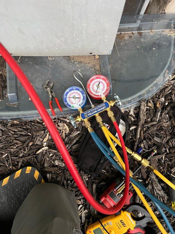 Responded to no cooling complaint on 44-year-old residential air conditioning system. Upon arrival, found indoor unit operating and calling for cooling, but outdoor unit not running. Inspection of outdoor unit revealed common wire burnt off at capacitor terminal. Tested dual-run capacitor rated 30/5 MFD and found hermetic side reading only 20 MFD, indicating capacitor failure and out of specification. 

Observed significant wear on contactor with heavy pitting on contact points. Condenser fan motor displayed restricted rotation with stiff bearings, indicating imminent failure. Connected manifold gauges to check system pressures; based on equipment age, suspect R-22 refrigerant. Recorded abnormal pressure readings suggesting potential refrigerant charge issues or additional system problems.

Performed temporary field repair by reconnecting burnt common wire to capacitor terminal to restore system operation. Tested system after repair and confirmed outdoor unit running with indoor unit. 