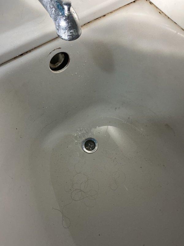 Responded to service call for reported clogged drain in basement with odors emanating from upstairs tub and kitchen drains. Upon arrival, assessed upstairs bathroom tub drain that was not draining properly. Inspected white porcelain sink basin, noting visible staining, mineral deposits, and discoloration around overflow drain and basin edges, consistent with long-term water exposure and potential drainage issues. Attempted to contact property owner to obtain authorization to proceed with drain cleaning and repair work, as tenant situation required landlord approval. Unable to reach property owner for service authorization. Without payment method on file and lacking owner consent, work could not be completed at this time. Property requires follow-up visit pending owner decision to authorize drain cleaning service to address suspected grease buildup in basement drain line near laundry area cleanout, similar to previous service history from prior year.