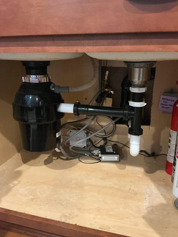 Responded to a kitchen sink backup affecting multiple fixtures in the residence. Upon diagnostic testing, identified a blockage in the shared basement drain line that caused water to back up within 30 seconds of operation. Cabled the basement sink drain to approximately 20 feet using mechanical drain cleaning equipment and successfully cleared the obstruction, which appeared to be dental floss material. Tested the drain system by running water for 10 minutes to confirm proper flow with no backup or leaks detected.

Removed the existing garbage disposal unit, which was infrequently used and producing odors. Installed a new basket strainer assembly with end waste connection to replace the disposal. Connected all drain components using appropriate PVC fittings and verified secure connections. Conducted thorough operational testing of the entire drainage system to ensure proper function and confirm no leaks were present at any connection points.

As an additional courtesy, resealed the bas