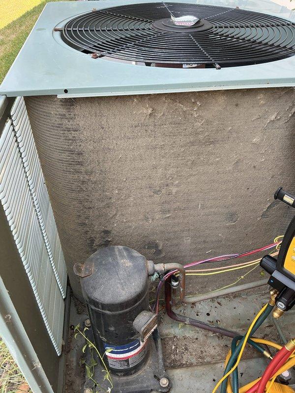 Responded to no cooling complaint on 16-year-old residential air conditioning system. Upon inspection, found failed dual run capacitor and heavily soiled outdoor condenser coil with significant dirt and debris accumulation restricting airflow. Replaced failed capacitor with proper rated replacement and performed thorough coil cleaning to restore heat transfer efficiency. Noted contactor showing wear with buzzing operation and pitted contacts, recommended for future replacement but currently functional. Performed complete system evaluation including refrigerant charge verification, amperage draws, temperature differentials, and operational testing of all components. All measurements within manufacturer specifications. System restored to full cooling operation with proper airflow and refrigerant levels confirmed.