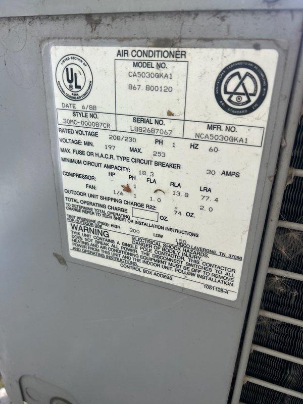 Responded to no cooling complaint on a 20-year-old air conditioning system experiencing frequent freeze-ups. Upon inspection, found unit severely low on R22 refrigerant and identified missing insulation on refrigerant lines where frost and ice had been accumulating. System manufactured in 1988 per nameplate data (Model CA50300KA1). Due to age of equipment, obsolete R22 refrigerant requirements, and ongoing refrigerant loss indicating likely leak in system, recommended complete air conditioning replacement rather than repair. Documented equipment condition and refrigerant deficiency with photos showing manufacturer specifications and evaporator coil area with dust accumulation. Customer advised that continued repairs would not be cost-effective given system age and refrigerant phase-out.