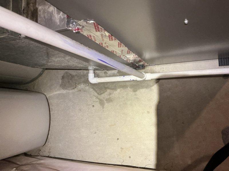 Responded to callback for condensate drain leak on recently installed furnace and AC system. Removed and replaced defective PVC elbow joint on condensation discharge line with proper solvent welding. Performed multiple water flow tests to verify leak repair and confirm proper drainage function with no further leakage detected at joint connection.