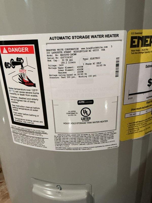 Responded to emergency call for water heater leaking from bottom and flooding basement. Upon arrival, found original unit installed in 1968, approximately 60 years old, actively leaking and causing water damage to basement floor. Assessed that tank had reached end of service life with catastrophic failure at base of unit. 

Shut off water supply and electrical power to failed water heater. Drained remaining water from old tank and disconnected all plumbing connections including cold water inlet and hot water outlet copper lines. Disconnected electrical wiring at junction box. Removed failed 50-gallon electric water heater from basement utility area and prepared installation site.

Installed new Bradford White 50-gallon electric water heater in same location against concrete block wall. Unit specifications include 240V operation with dual 4500W heating elements (upper and lower). Connected copper supply lines to top of new tank, ensuring proper hot and cold water line orientation. Recon