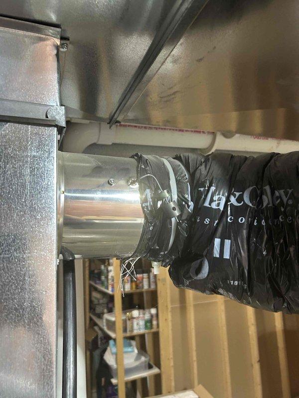 Responded to recurring condensation issue in insulated fresh air intake ductwork on 2-year-old Lennox system. Upon inspection, identified fresh air damper in fully open position, causing excessive humid outdoor air infiltration during blower operation. Basement temperature measured at 53°F due to aggressive thermostat setpoint, creating significant temperature differential on ductwork despite insulation. Drained accumulated water from affected ductwork and adjusted fresh air damper to minimal opening position to reduce humidity intake while maintaining code-required ventilation. Explained condensation mechanism to occupant, noting that combination of cold basement temperatures and humid air infiltration will continue to challenge insulation effectiveness. System operating normally with adequate cooling capacity. Recommended monitoring for recurrence and potential consideration of thermostat adjustment to reduce extreme temperature differential.