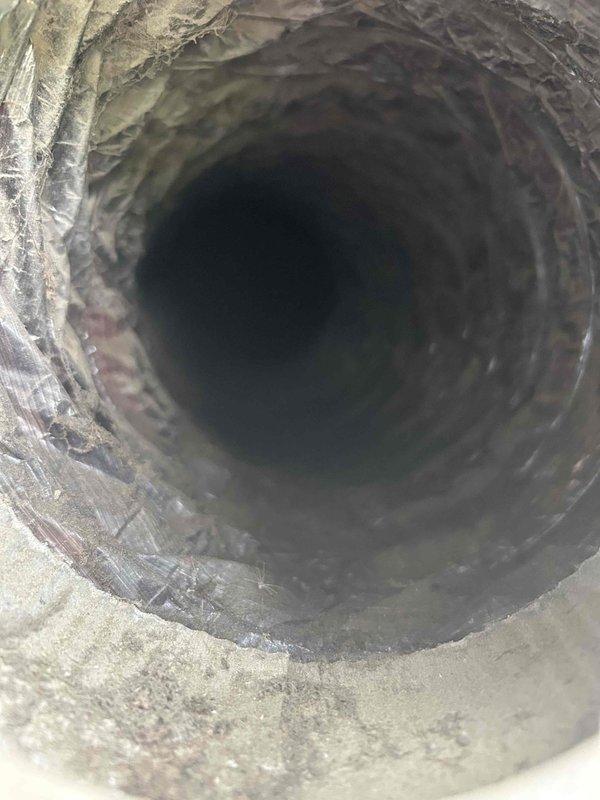 Responded to recurring condensation issue in insulated fresh air intake ductwork on 2-year-old Lennox system. Upon inspection, identified fresh air damper in fully open position, causing excessive humid outdoor air infiltration during blower operation. Basement temperature measured at 53°F due to aggressive thermostat setpoint, creating significant temperature differential on ductwork despite insulation. Drained accumulated water from affected ductwork and adjusted fresh air damper to minimal opening position to reduce humidity intake while maintaining code-required ventilation. Explained condensation mechanism to occupant, noting that combination of cold basement temperatures and humid air infiltration will continue to challenge insulation effectiveness. System operating normally with adequate cooling capacity. Recommended monitoring for recurrence and potential consideration of thermostat adjustment to reduce extreme temperature differential.