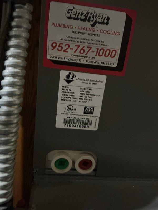 Responded to no cooling complaint on 17-year-old air conditioning system blowing warm air. Upon arrival, found system not running with low pressure switch tripped due to low refrigerant charge. Temporarily bypassed low pressure switch to verify system operation and confirm refrigerant leak in system. Diagnosed refrigerant loss requiring leak search and repair. Documented equipment condition with photos of mechanical room showing water heater, HVAC components, and piping configuration, as well as unit nameplate information. Provided customer with repair options including refrigerant recharge, leak detection and repair, or full system replacement given age of equipment. Scheduled same-day estimate appointment for new air conditioning system replacement.
