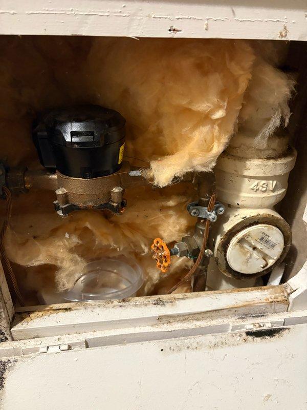 Responded to reported basement water leak initially suspected to be from sump pump. Upon inspection, identified leak originating from water meter assembly rather than sump pump system. Examined under-sink plumbing area and utility spaces including water heater location to confirm source. Advised homeowner that water meter is municipal property and responsibility, instructed them to contact city water department for repair as this falls outside homeowner plumbing system jurisdiction.