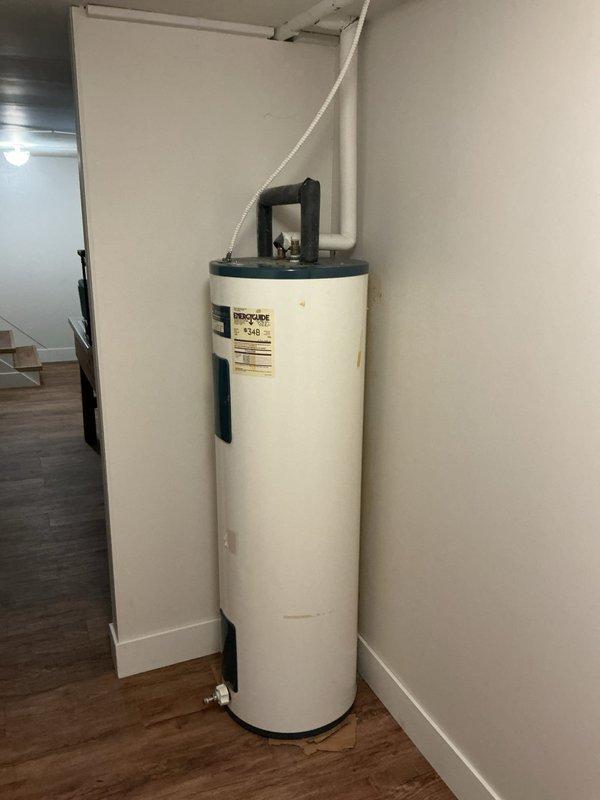 Responded to reported basement water leak initially suspected to be from sump pump. Upon inspection, identified leak originating from water meter assembly rather than sump pump system. Examined under-sink plumbing area and utility spaces including water heater location to confirm source. Advised homeowner that water meter is municipal property and responsibility, instructed them to contact city water department for repair as this falls outside homeowner plumbing system jurisdiction.