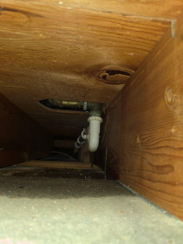 Responded to a tub drain leak causing water damage to basement ceiling and ductwork below. Created wall access to diagnose the issue and discovered a deteriorated tub/shower valve and cracked drain assembly. Installed new Moen tub and shower valve along with complete tub waste and overflow replacement. Conducted pressure testing by filling tub and running showerhead to verify proper operation and confirm leak resolution. Noted existing rust damage on ductwork beneath repair area from prolonged water exposure, recommended separate HVAC assessment for affected components.