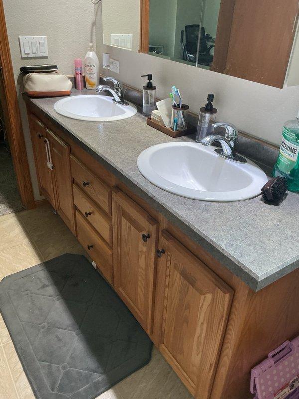 Responded to a leaking toilet in the master bathroom. Upon inspection, identified a faulty fill valve leaking from the top of the tank, causing water to run down the side and pool on the floor beneath the toilet. Removed the defective fill valve and installed a new replacement unit, restoring proper operation and eliminating the leak. Customer also reported a slight rotten egg odor in the water supply; advised that the well had been previously shocked and a filtration system installed, and recommended potential water testing and additional well treatment if the odor persists.