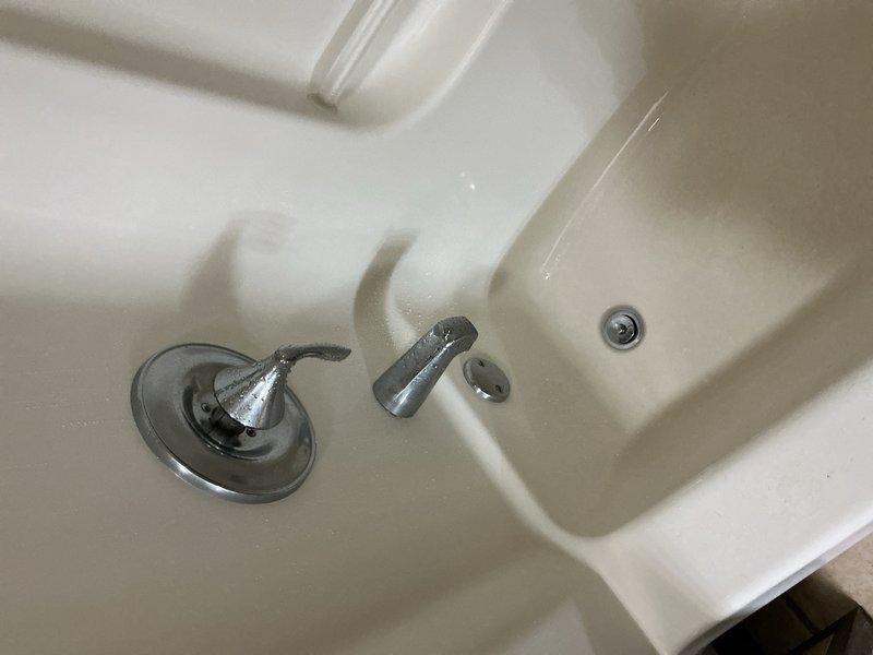 Completed comprehensive plumbing inspection of residential property. Inspected water treatment system including softener tank, filtration unit with digital control head, and associated copper piping connections in basement utility area. Evaluated bathroom fixtures including tub/shower assembly with chrome hardware and identified toilet components requiring replacement due to wear and deterioration.