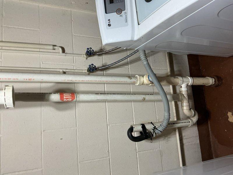 Responded to drainage issue within scheduled arrival window. Utilized blow bag method to clear obstruction in drain line. Encountered significant grease accumulation around cast iron piping that required additional clearing efforts. Successfully cleared blockage and restored proper drainage function. Documented plumbing installation including PVC drainage assembly, water heater connections, and laundry room utility hookups with photographic evidence.