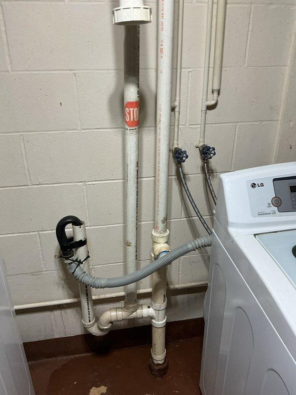 Responded to drainage issue within scheduled arrival window. Utilized blow bag method to clear obstruction in drain line. Encountered significant grease accumulation around cast iron piping that required additional clearing efforts. Successfully cleared blockage and restored proper drainage function. Documented plumbing installation including PVC drainage assembly, water heater connections, and laundry room utility hookups with photographic evidence.