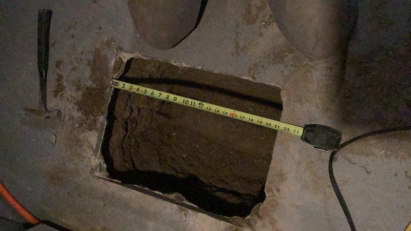 Cut and removed concrete floor section to access underground plumbing. Removed existing cast iron pipe and cable sleeve from excavated area. Installed new PVC pipe to replace damaged section and completed repair connection. Temporarily covered opening with plywood for safety until concrete restoration can be completed.
