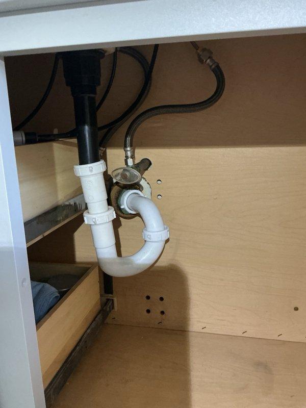 Removed existing bathroom vanity faucet and installed customer-supplied widespread faucet with brushed nickel finish on white solid surface countertop. Connected new three-piece faucet assembly to existing supply lines and shut-off valves. Installed new drain assembly and P-trap configuration, ensuring proper alignment and leak-free connections. Tested water flow through both hot and cold handles, verified drainage function, and confirmed all plumbing connections were secure with no leaks detected.