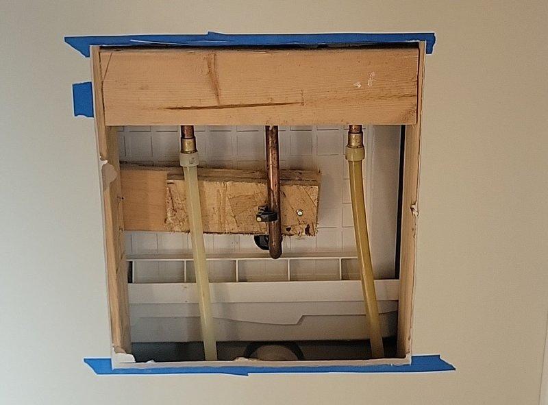 Responded to water line break in bathroom shower system. Upon inspection, identified cracked copper tub spout arm at the bend joint, which had developed a failure point causing active water leakage. Created wall access opening to expose the plumbing assembly and assess the full extent of the damage. The copper pipe exhibited significant corrosion and oxidation, particularly concentrated at the U-bend section where the crack had formed. Removed the damaged tub spout arm and installed a replacement component. Verified all connections for proper seal and tested the system under full water pressure to confirm leak resolution and restore normal operation.