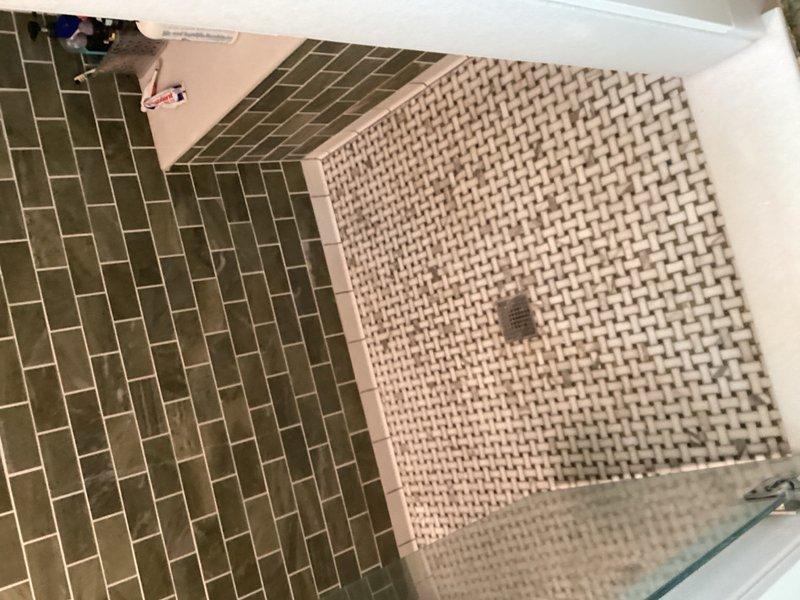Returned to property to complete shower head installation following earlier appointment. Successfully installed replacement shower head unit on chrome shower arm in bathroom with herringbone-patterned tile. Verified proper water flow and secure mounting upon completion.