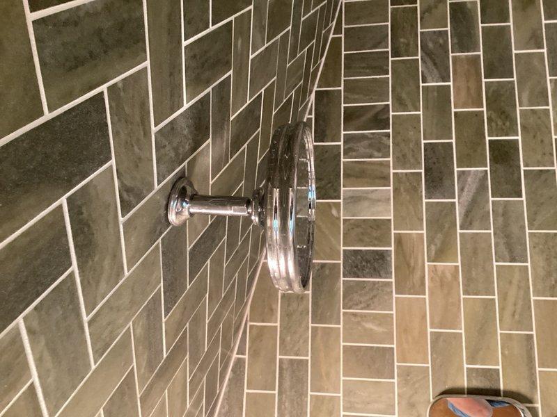 Returned to property to complete shower head installation following earlier appointment. Successfully installed replacement shower head unit on chrome shower arm in bathroom with herringbone-patterned tile. Verified proper water flow and secure mounting upon completion.