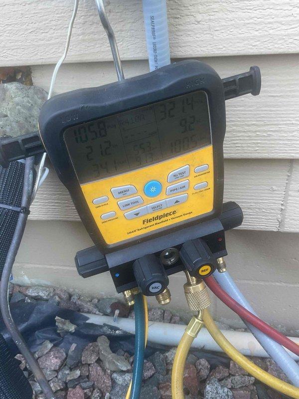 Responded to no cooling complaint on residential HVAC system. Upon arrival, discovered frozen refrigerant line from outdoor condenser to indoor coil and severely restricted airflow due to dirty evaporator coil. Used digital manifold gauges to assess system pressures and confirmed abnormal operating conditions. Found condensate drainage issue causing water accumulation in mechanical room, related to previous condenser installation. Evaporator coil access proved challenging due to metal bracket assembly requiring disassembly. Placed collection bucket to manage condensate leakage. System requires evaporator coil cleaning or replacement and proper drainage configuration. Scheduled return visit with additional technician to facilitate coil removal and complete necessary repairs.