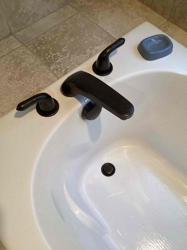 Responded to service call for leaking bathroom faucet and shut-off valves. Replaced worn cartridges in black three-piece faucet assembly and installed new shut-off valves to eliminate all leaks. Tested system for proper operation and verified no additional leaks present upon completion.
