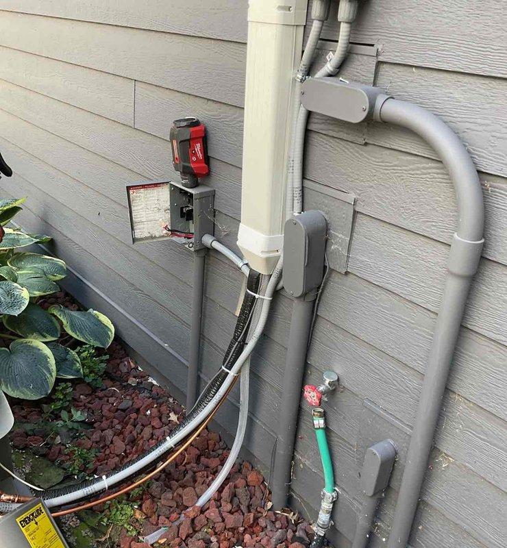 Completed full HVAC system replacement in upstairs closet, installing EL15KC1 2-ton air conditioner (up to 15.9 SEER2, single stage) and matching cased coil with factory-installed TXV valve. Installed new air handler with fresh drain pan and wet puck safety switch. Adapted supply and return plenum connections and concealed refrigerant lines with line hide. Replaced outdoor AC pad, re-leveled with pea gravel, and ran new refrigerant lines to condenser unit. Installed new condensate drain line routed to exterior matching existing configuration.

Upgraded to Honeywell T6 WiFi thermostat and corrected electrical wiring issues discovered during installation. Installed new disconnect switch for air handler and relocated AC disconnect box to meet current code requirements. Secured all exterior electrical conduit and PVC piping to siding with proper mounting brackets. Verified all electrical connections at panel box with eight circuit breakers properly labeled and secured.

System tested and o