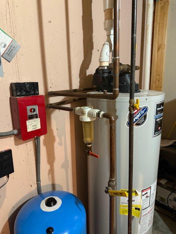 Responded to emergency water leak in mechanical room where a cracked copper pipe feeding the acid neutralizer caused basement flooding. Homeowner had shut off well pump to prevent further water damage upon our arrival. Removed and replaced the corroded section of copper piping, including installation of a new 90-degree elbow fitting to restore water flow to the acid neutralizer system. Water service was successfully restored to the home, and provided estimate for complete acid neutralizer replacement and comprehensive water system repiping due to visible corrosion throughout existing plumbing infrastructure.