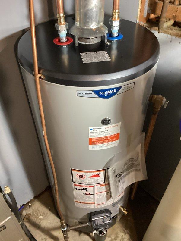 Responded to service call for reported leak at water heater. Upon inspection, identified leak originating from the hot water outlet dielectric union connection at top of tank. Tightened the dielectric union fitting to stop the leak and cleaned up accumulated water from the unit and surrounding area. Verified repair was successful with no further leakage observed. Documented repair with photographs of the affected plumbing connections and overall water heater installation.