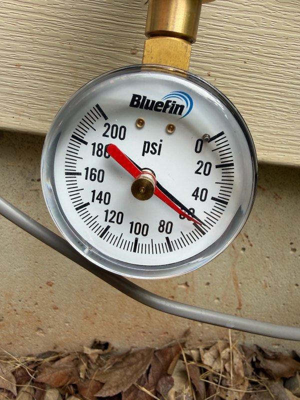 Completed comprehensive plumbing system inspection as part of recurring maintenance program. Evaluated water pressure at exterior connection point using calibrated gauge, confirming system operating within normal PSI parameters. Inspected interior copper piping installation, noting advanced corrosion and green patina formation on multiple sections indicating ongoing oxidation concerns that will require monitoring for potential future replacement.