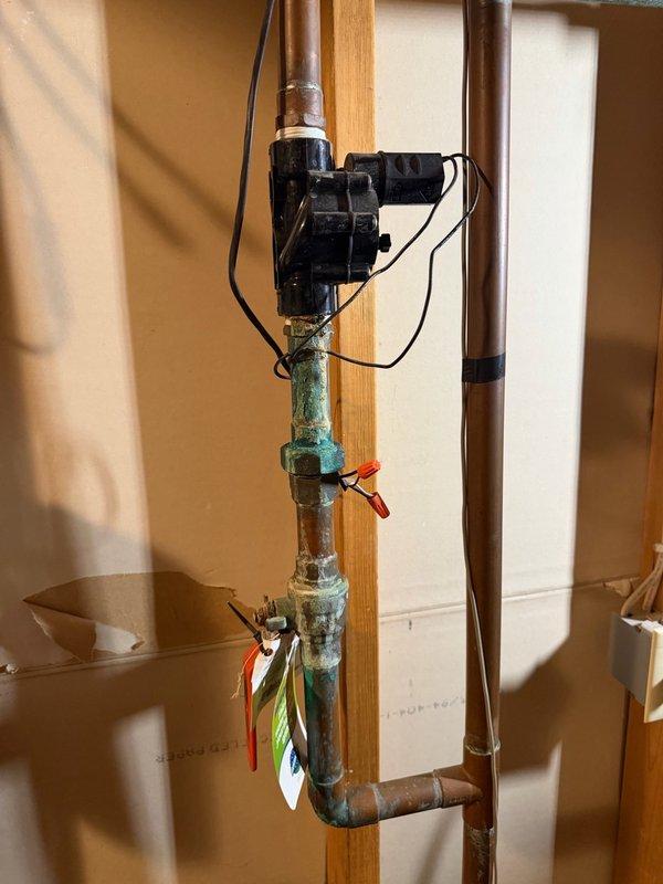 Completed comprehensive plumbing system inspection as part of recurring maintenance program. Evaluated water pressure at exterior connection point using calibrated gauge, confirming system operating within normal PSI parameters. Inspected interior copper piping installation, noting advanced corrosion and green patina formation on multiple sections indicating ongoing oxidation concerns that will require monitoring for potential future replacement.