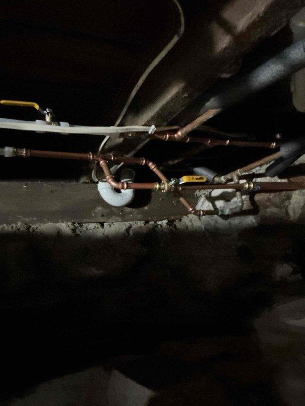 Responded to emergency service call for foreclosed property requiring water service restoration. Property had not been properly winterized, resulting in multiple leak points throughout the basement plumbing system. Conducted diagnostic assessment of exposed basement piping to identify all compromised sections and connections.

Performed minor repipe of damaged water supply lines using copper pipe and appropriate fittings. Replaced failed sections of piping that had frozen and burst during winter months. Installed new pipe connections and secured all lines to floor joists per code requirements. Integrated white PVC drainage components with existing copper supply lines where necessary.

Verified all new joints were properly soldered and pressure-tested system to ensure leak-free operation. Confirmed water service could be safely restored to property. All repairs completed to bring plumbing system back to functional condition for occupancy.