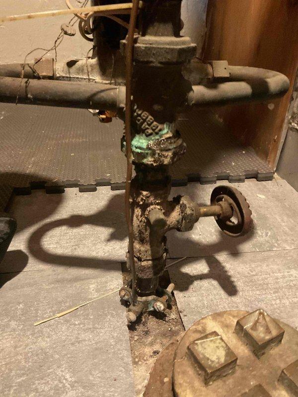 Responded to water leak at main service line shutoff valve. Upon inspection, found severely corroded vertical pipe assembly with extensive rust deterioration throughout the central section and compromised structural integrity at the base mounting platform. The main shutoff valve and surrounding piping exhibited advanced corrosion requiring immediate attention to prevent catastrophic failure. Additionally assessed drainage issues under kitchen sink and discussed potential garbage disposal installation. Documented existing conditions with photographs and provided estimate for main service line repair to address the active leak and prevent further water damage.