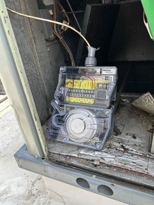 Completed warranty repair by replacing defective smoke detector with new style unit on HVAC system control panel. Removed old detector from electronic control housing, installed updated smoke detector model, verified proper wiring connections at terminal block, and performed alarm function test to confirm operational status.