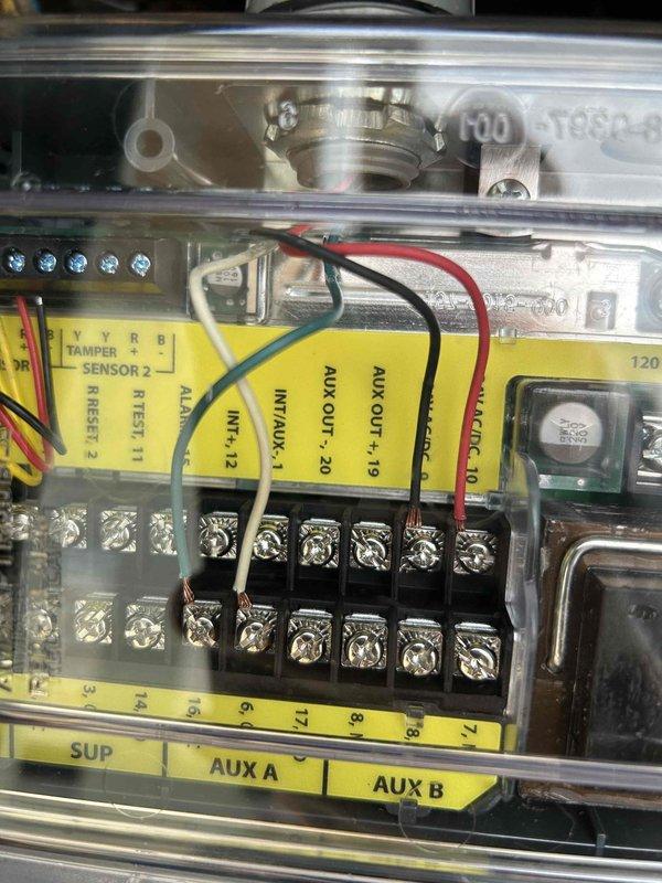 Completed warranty repair by replacing defective smoke detector with new style unit on HVAC system control panel. Removed old detector from electronic control housing, installed updated smoke detector model, verified proper wiring connections at terminal block, and performed alarm function test to confirm operational status.