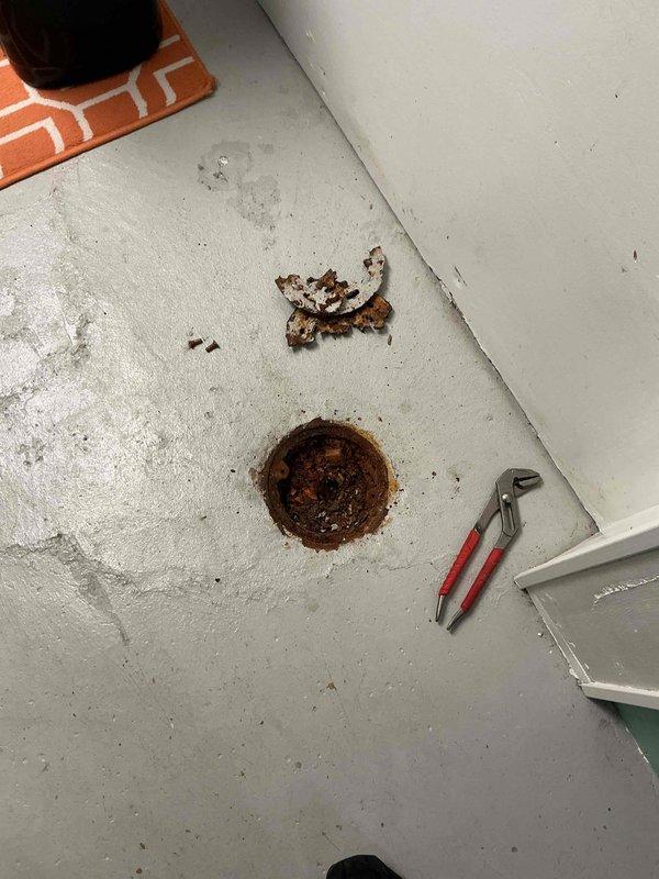Responded to service call for malfunctioning floor drains at commercial property. Upon inspection, identified two separate issues requiring immediate attention: first floor drain missing functional cleanout cap, second floor drain completely obstructed with accumulated rust debris.

Installed new cleanout cap on first floor drain and performed operational testing to ensure proper sealing and functionality. Addressed second floor drain by removing grate assembly to access blockage. Found drain bowl filled with heavy rust accumulation preventing water flow. Removed rust debris using vacuum extraction method to clear basin area.

Performed mechanical cable cleaning of affected drain line to restore flow capacity and remove any remaining obstructions in the pipe. Successfully cleared blockage and verified line was flowing properly. Conducted final testing by flushing multiple buckets of water through both floor drain systems to confirm complete restoration of drainage function and proper o
