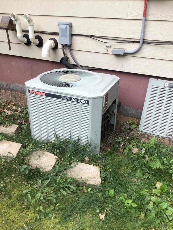 Performed comprehensive annual maintenance on Trane XE 1000 air conditioning system. Thoroughly cleaned outdoor condensing unit coil to ensure optimal heat transfer and system efficiency. Conducted complete electrical system testing including voltage, amperage, and capacitor readings, confirming all components operating within manufacturer specifications. Measured supply and return air temperatures, recording an 18-degree temperature differential, which falls within proper cooling range. System operating normally with no deficiencies noted.