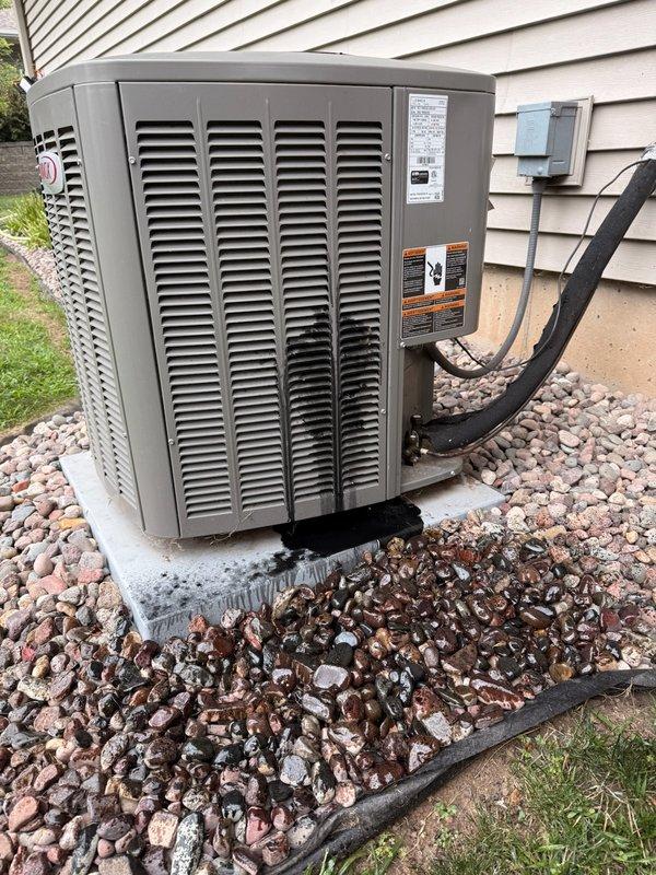 Responded to no cooling call on 3-year-old residential AC system. Upon arrival, found outdoor unit inoperative with evidence of catastrophic compressor failure - customer reported loud popping noise followed by black liquid discharge from unit. Inspection confirmed compressor had mechanically failed and blown out a retaining pin, rendering system unable to operate. Documented equipment condition with photos showing outdoor condensing unit and internal electrical components including capacitor. Advised customer of compressor failure and initiated warranty claim process given unit is well within 10-year parts coverage period.