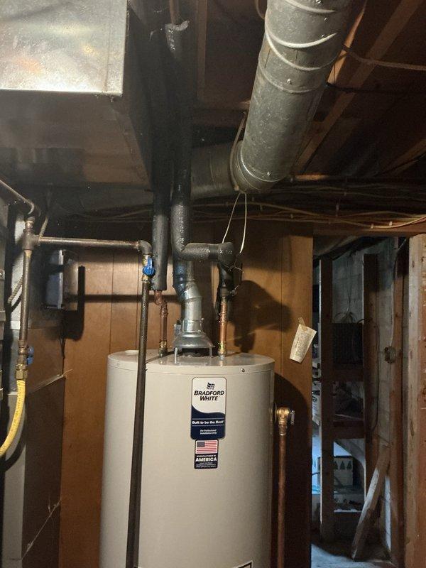 Responded to water heater leak in residential basement where unit was still producing hot water but had developed a small pinhole leak in the tank. Upon inspection, determined the tank failure required full replacement rather than repair. Removed existing failed water heater and installed new Bradford White 50-gallon standard vent natural gas water heater. Connected all supply and discharge piping, verified proper venting through existing ductwork, installed required safety valves, and tested unit for proper operation and absence of leaks. Unit commissioned successfully with hot water delivery confirmed.