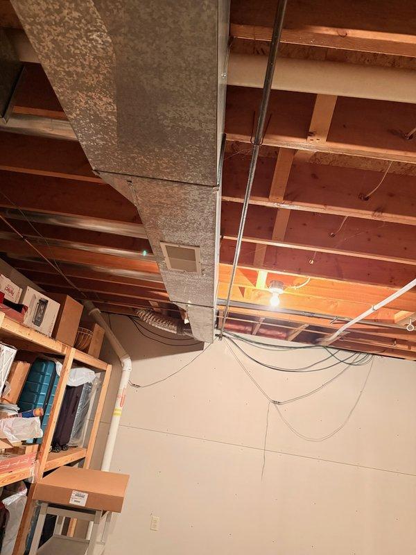 Responded to emergency water leak in basement with active flooding. Upon arrival, found supply line had completely detached from shut-off valve, causing continuous water discharge through basement vent despite main water supply being shut off to home. Secured the disconnected supply line and properly reconnected it to the shut-off valve, restoring proper connection and stopping the leak. Verified system integrity and confirmed no further water discharge. Documented conditions of affected bathroom area and basement with photographs showing finished bathroom space and unfinished basement with exposed joists and mechanical systems.