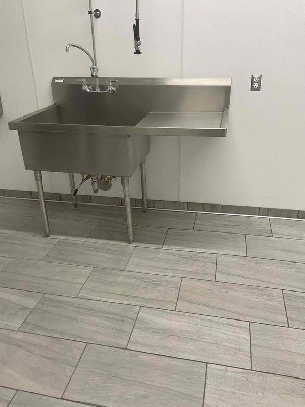 Conducted on-site evaluation for garbage disposal installation under commercial-grade stainless steel sink with drainboard. Assessed existing plumbing configuration including P-trap assembly, tailpiece connections, and supply line accessibility, then provided comprehensive installation estimates to customer.