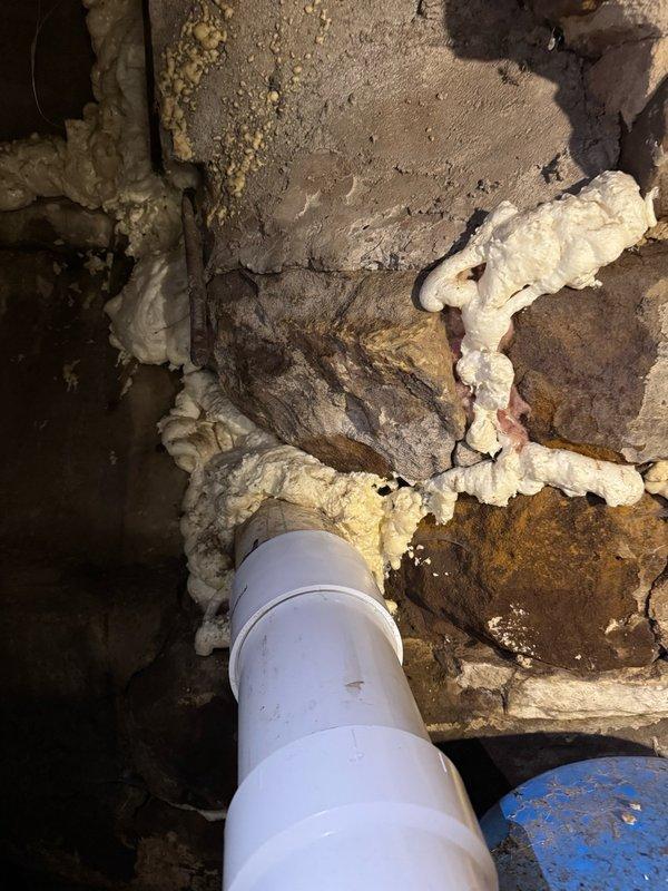 Responded to active water leak and backed-up main sewer line. Upon investigation, discovered a 4-inch PVC pipe exiting the foundation from the septic tank had a burn hole on the top surface, causing the leak. The main sewer line was also experiencing backup issues. Cut out the damaged section of 4-inch pipe and replaced it with new pipe and fittings. During troubleshooting, found the breaker for the septic pump had been switched off; restored power to the pump, which resolved the backup problem. System tested and returned to normal operation.