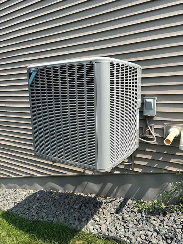 Completed annual cooling maintenance on one Daikin AC system with 410A refrigerant under ambient conditions of 83 degrees. Inspected indoor air handler including filter, drain pan, blower motor, electrical wiring, and components with all items found satisfactory. Verified temperature split across evaporator coil within acceptable range. Inspected outdoor condenser unit including coil cleanliness and electrical components. Identified dual-run capacitor (45+5 MFD) reading outside manufacturer specifications and recommended replacement with estimate provided. Verified amp draw on condenser fan motor, compressor, and contactor within normal operating parameters. Confirmed refrigerant charge at proper levels with no leaks detected. Discovered condensation accumulation inside furnace chamber, likely attributed to intake air configuration combined with elevated outdoor temperatures and humidity. Recommended installation of inline drain on combustion air intake to prevent future moisture infil