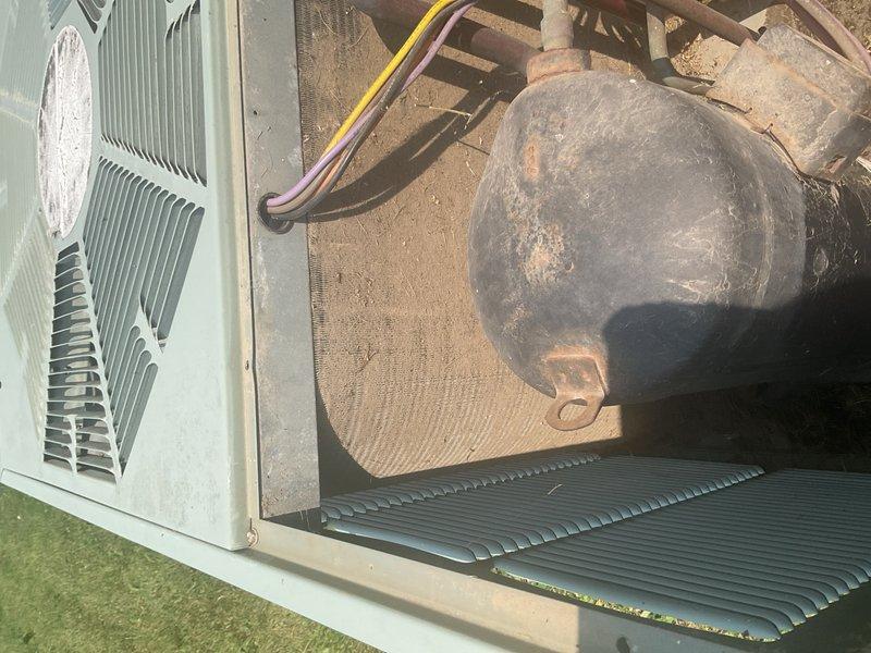 Responded to emergency no-cool call at commercial auto body shop with water leaking through ceiling tiles in main office area. Found approximately 30-year-old RUUD unitary R-22 rooftop system with completely frozen suction line and evaporator coil causing active water damage to ceiling tiles and flooring. Initial diagnostic readings at 93°F outdoor ambient showed abnormal 120 psig on both suction and liquid lines. Inspection revealed condenser coil heavily plugged with grass clippings and debris, severely restricting heat rejection, along with dirty 20x20x1 filter that had not been serviced in approximately three months, causing critical airflow restriction. 

Performed thorough condenser coil cleaning to remove debris buildup and replaced dirty air filter. Allowed frozen coil to thaw completely before restart. Upon system restart, monitored performance and recorded only 12-13°F temperature split after 15-minute runtime, confirming significant underperformance typical of aged equipment