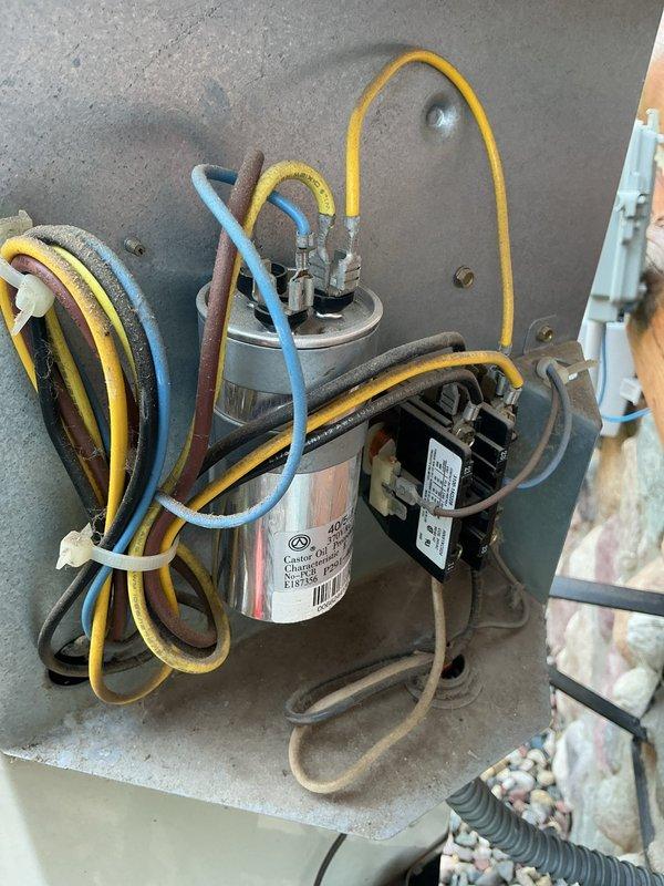 Responded to no-cooling complaint on 20+ year old R22 system with indoor temperature at 85°F. Found tripped breaker and failed capacitor upon arrival. Reset breaker and replaced failed capacitor, which had been damaged by a failing compressor. During system testing, identified compressor operating with excessive noise and reduced efficiency, indicating imminent failure. Compressor condition was the root cause of both the capacitor failure and circuit breaker trip. Restored cooling operation temporarily, but advised customer this is a temporary repair with no guarantee due to the compressor's deteriorated condition and the system's use of obsolete R22 refrigerant. Scheduled system replacement estimate.