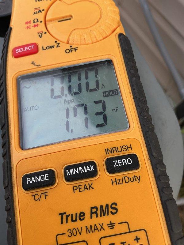 Responded to no cooling complaint on 22-year-old central air conditioning system. Upon arrival, confirmed outdoor condenser fan motor was experiencing delayed start and running at reduced speed, with unit blowing room temperature air through vents. Diagnostic testing revealed failed dual run capacitor on fan circuit, verified through multimeter readings showing capacitance outside acceptable range. Replaced defective dual run capacitor and confirmed proper amperage draw and voltage supply to compressor and condenser fan motor. System previously diagnosed as low on R410A refrigerant charge during earlier service visit. Restored system to operational status with condenser fan motor starting immediately and running at proper speed.