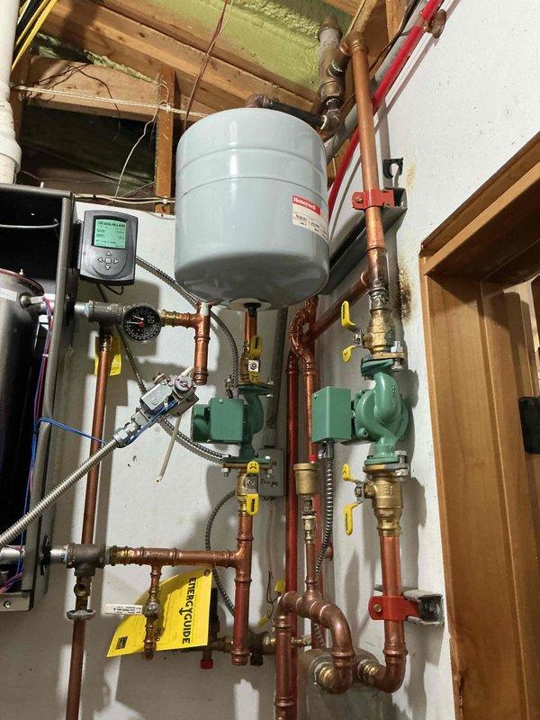 Performed comprehensive boiler tune-up on hydronic in-floor heating system. Removed burner assembly from heat exchanger, thoroughly cleaned heat exchanger components, and flushed system with water to remove accumulated debris and sediment. Cleaned flame sensor and igniter, reassembled all components, and started unit to verify proper operation. System brought to full operating temperature and confirmed running within normal parameters with all circulation pumps and controls functioning correctly.