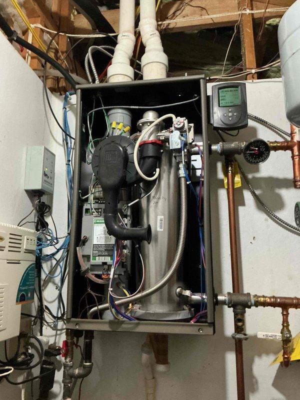 Performed comprehensive boiler tune-up on hydronic in-floor heating system. Removed burner assembly from heat exchanger, thoroughly cleaned heat exchanger components, and flushed system with water to remove accumulated debris and sediment. Cleaned flame sensor and igniter, reassembled all components, and started unit to verify proper operation. System brought to full operating temperature and confirmed running within normal parameters with all circulation pumps and controls functioning correctly.