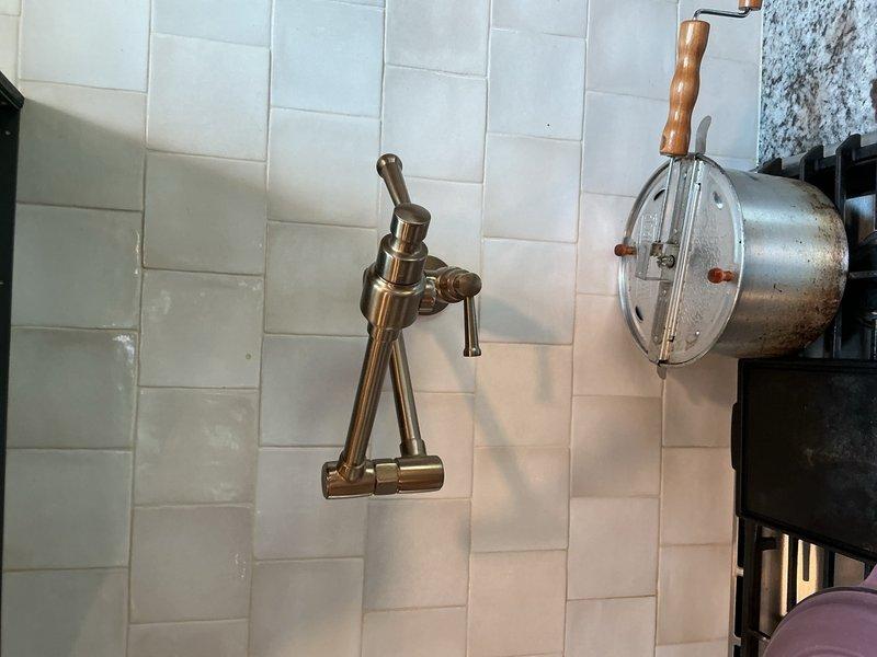 Completed comprehensive plumbing inspection identifying multiple issues requiring attention. Pot filler fixture exhibiting slow drip leak and discharging brown water, determined unit requires full replacement. Undermount kitchen sink found improperly secured and floating, needs complete remounting with proper support brackets and sealant. Master bathroom tub faucet also running brown water, indicating sediment buildup or corrosion in supply lines requiring investigation and potential pipe replacement. Additional bathroom identified as needing complete plumbing renovation. Documented all findings with photographic evidence for repair planning and customer review.